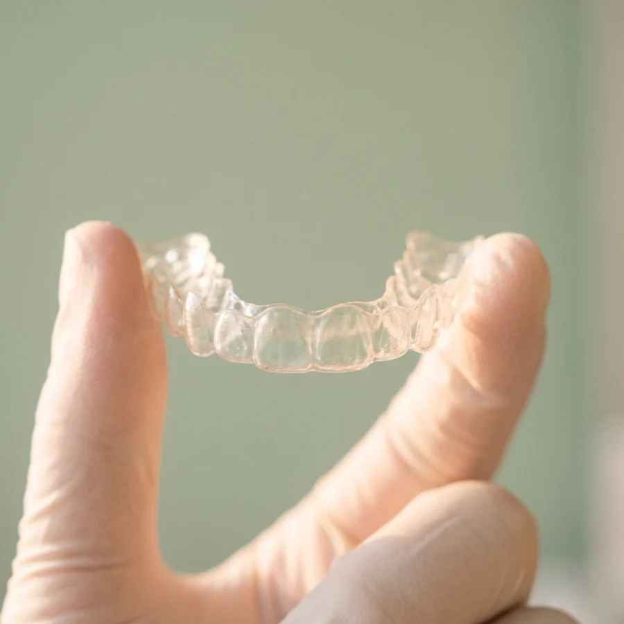 Alineador transparente sostenido entre dos dedos