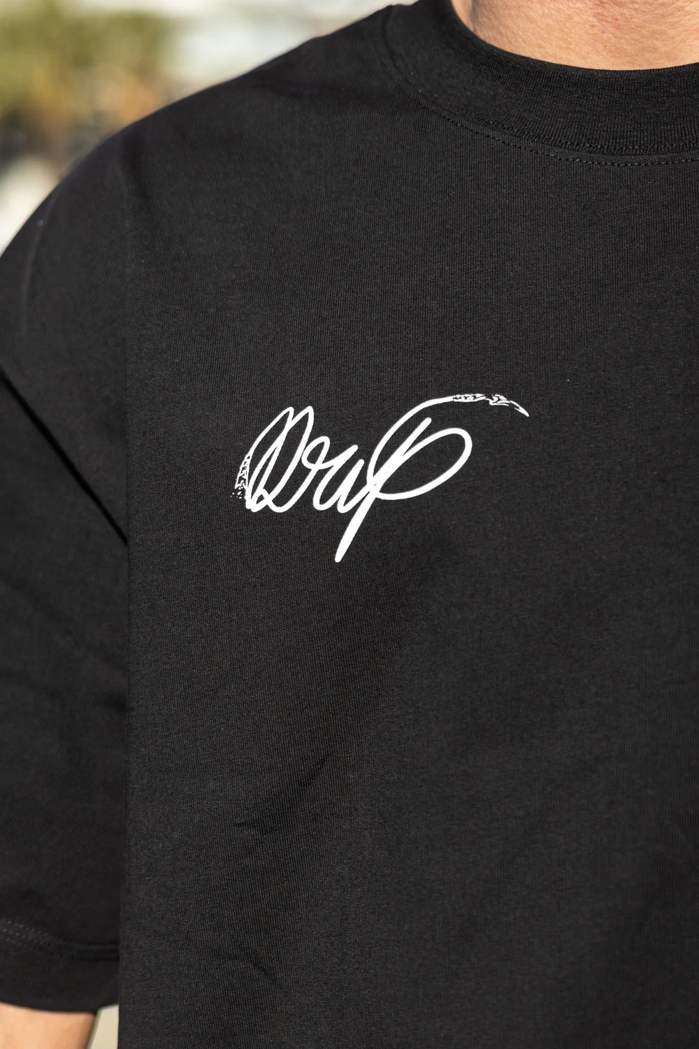 Detalle del logo Drip serigrafiado en el pecho de la camiseta